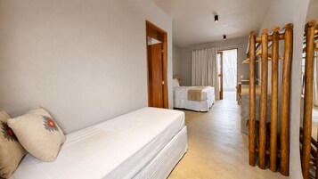 Una habitación de hotel con cama, separador de madera y vista a otra habitación.