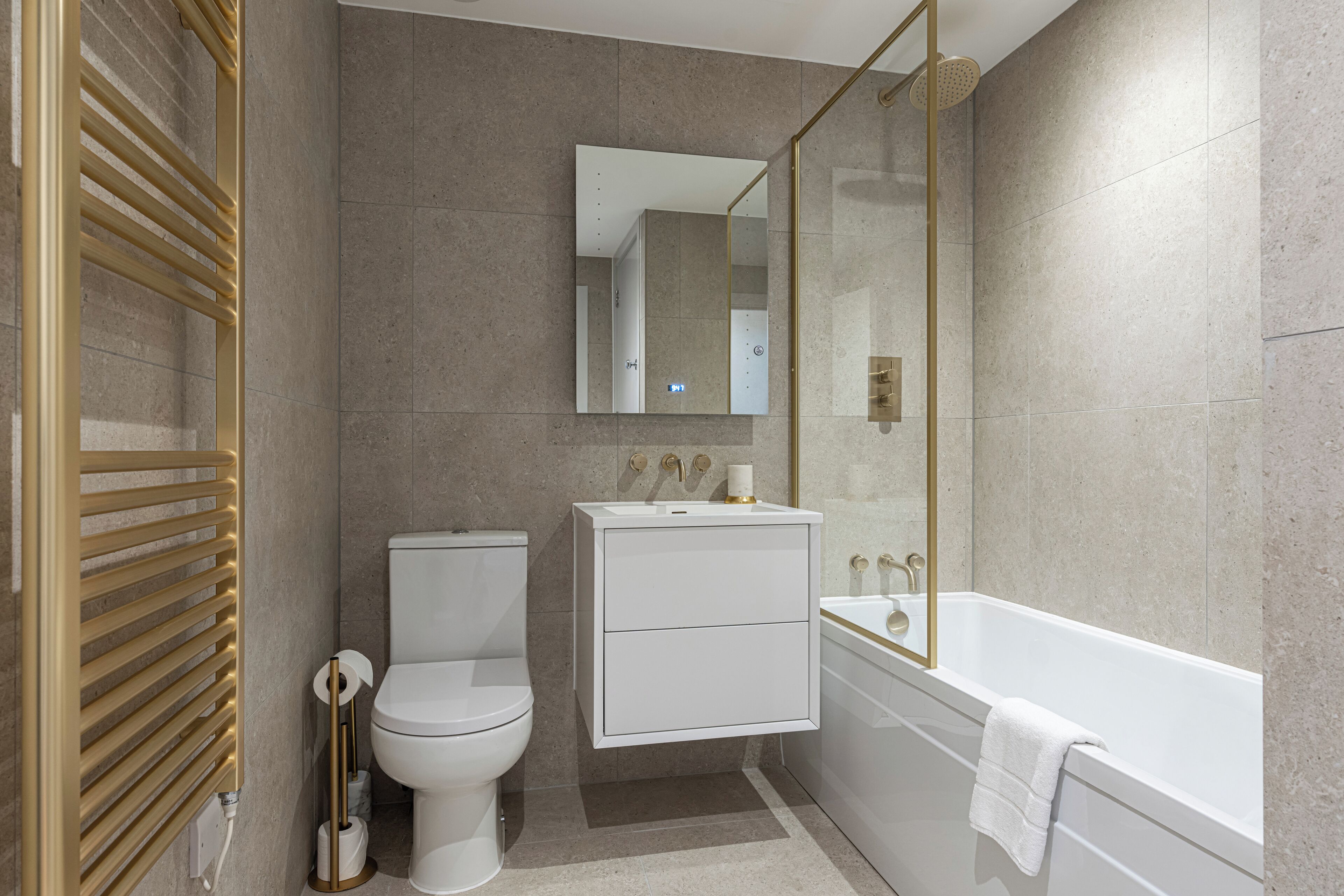 A modern bathroom with a toilet, sink, and bathtub.