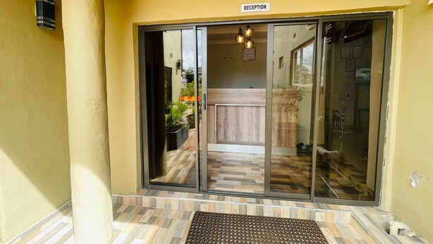 Un área de recepción con un cartel, techo de madera y suelo de baldosas.