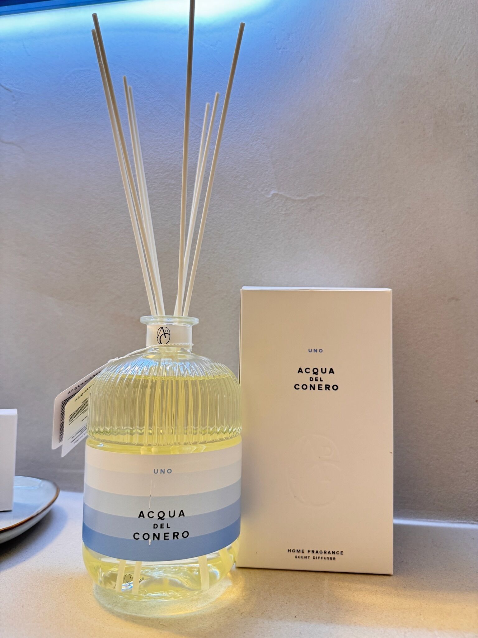 A bottle of Aqua del Cenero home fragrance diffuser with a matching box.