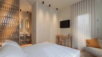 Une chambre d’hôtel avec un lit, un bureau, une chaise, une télévision et un canapé.