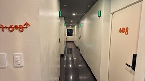 A hotel corridor with directional signs, emergency exit lights, and a door marked with the number 608. - Samcheok NS Hostel & Motel  (Samcheok)