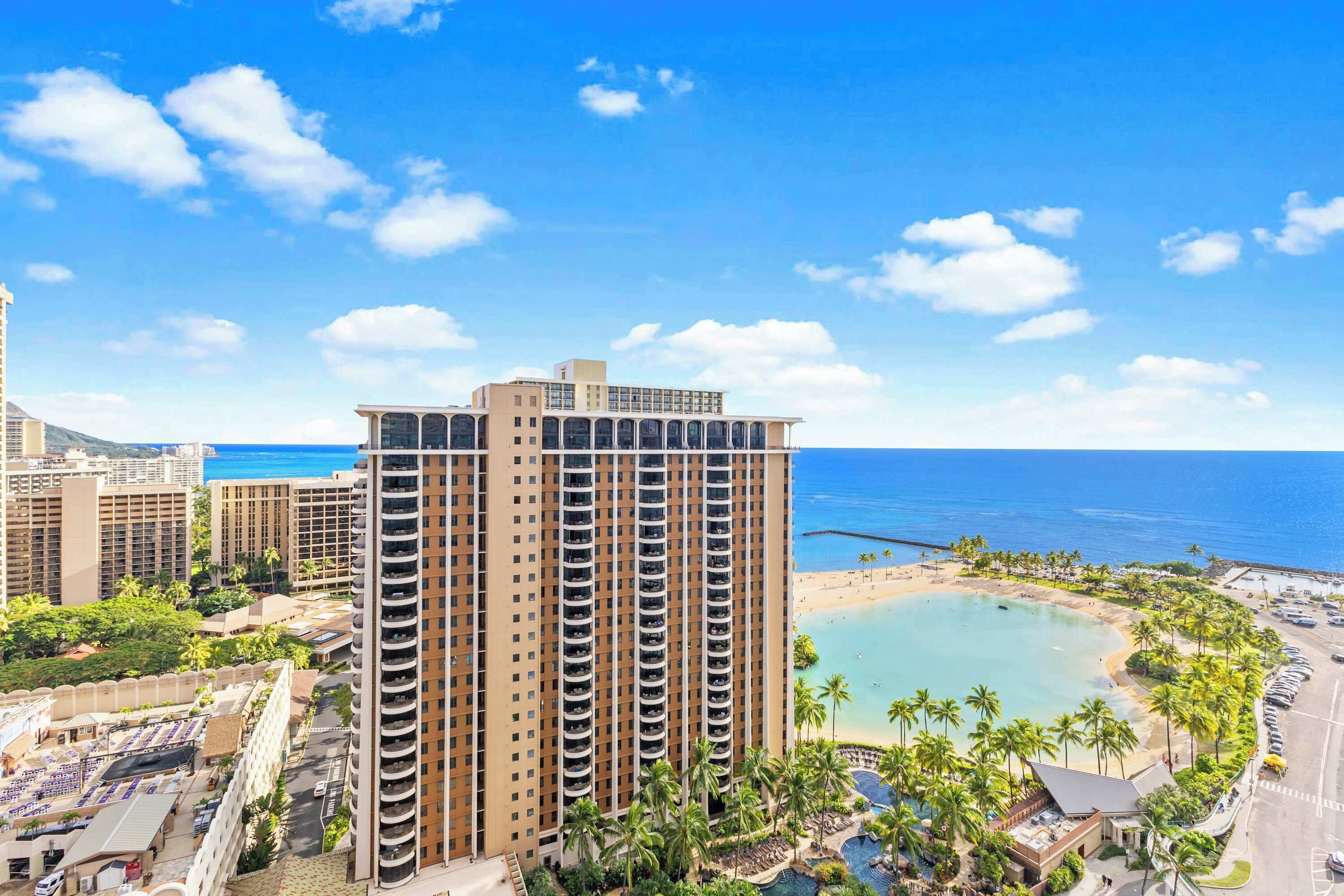 Een hoog hotel met zwembad, strand en uitzicht op de oceaan.
