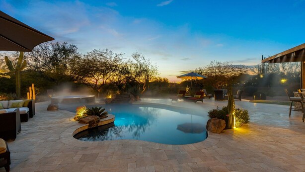 A heated outdoor swimming pool with lounge chairs and a hot tub, surrounded by a landscaped garden and patio area. - NEW RENOVATION! A Modern Twist on Southwest Living (Scottsdale)