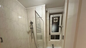 Une salle de bain avec une baignoire, une douche et un lavabo.
