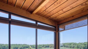 A hot tub with a view of a green landscape through large windows. - L'Orée du Bois du Domaine des Hauts de Rouquette (Eymet)
