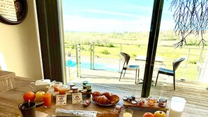 A dining area with a table set for breakfast, including croissants, fruit, and a milk jug. - L'Orée du Bois du Domaine des Hauts de Rouquette (Eymet)