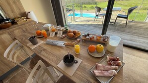 A breakfast table with croissants, pastries, jams, and a tray of ham. - L'Orée du Bois du Domaine des Hauts de Rouquette (Eymet)
