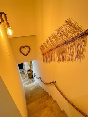 A staircase with a rope handrail, a heart-shaped decoration, and a feather-like wall hanging. - Villa Paradis 2 Sun Sea and Beach (Valras-Plage)