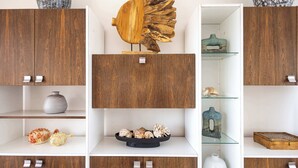 Une pièce dotée de meubles de rangement en bois, d’une sculpture de poisson décorative placée au centre et de divers objets disposés sur des étagères.