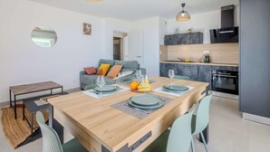 A modern kitchen with a wooden table set for dining, a built-in oven, and a black refrigerator.