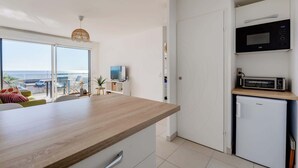 A modern kitchen with a wooden countertop, a microwave, a toaster, and a small refrigerator. - Valras'Loc Archipel Capri Balcony over the Sea (Valras-Plage)
