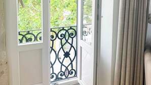 A room with a large window, a door, and a curtain. - Live Sintra Boutique Guest House (Sintra)