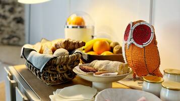 A kitchen counter with various food items, including bread, pastries, and a decorative owl.