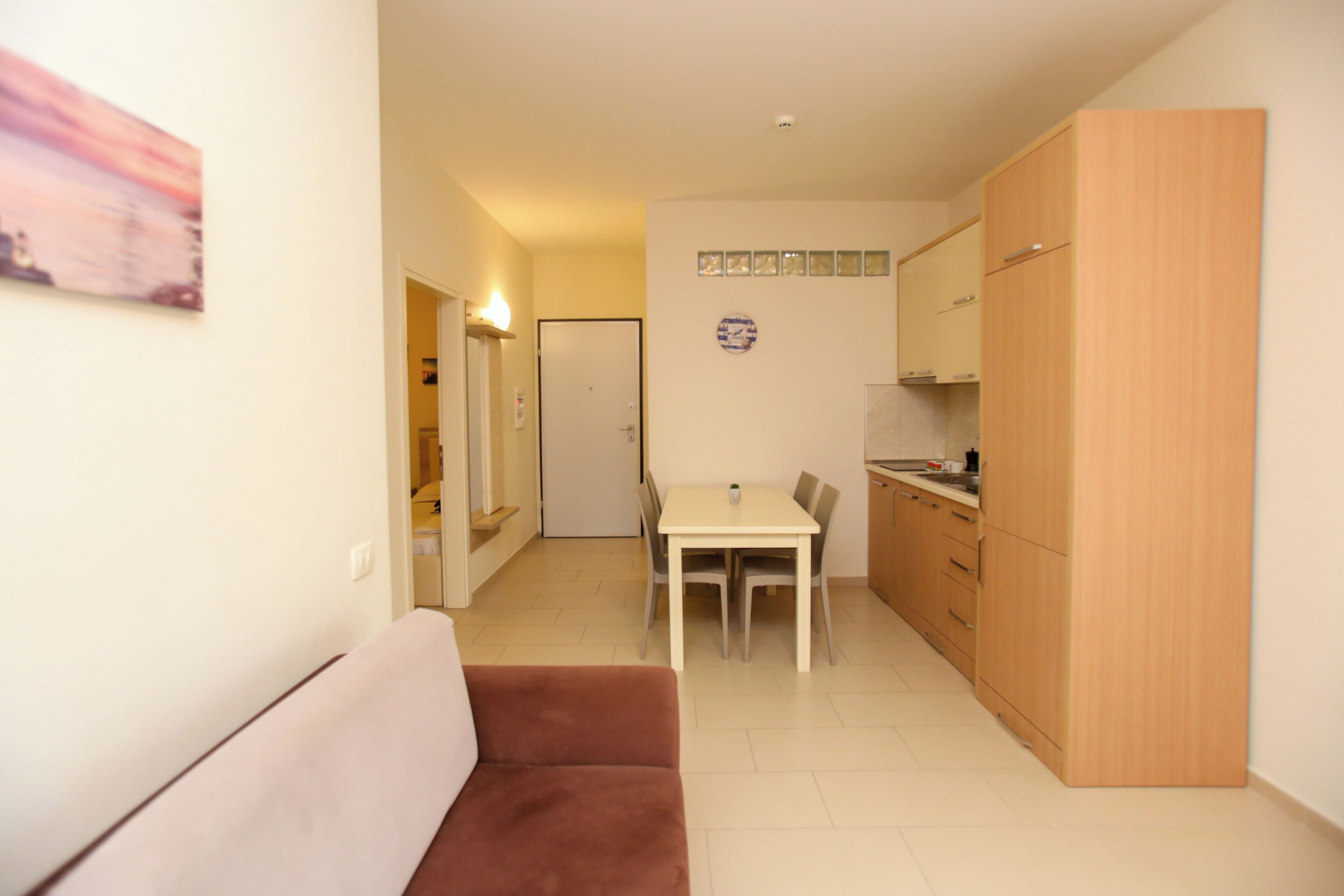 A compact living space with a kitchenette, a dining area, and a sofa.