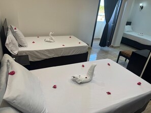 A hotel room with two beds, each adorned with a swan-shaped towel and scattered rose petals. - Summer Land Hotel (Abu Simbel)