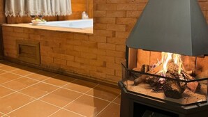 Un poêle à bois avec une cheminée, une fenêtre avec un rideau et un plancher carrelé.