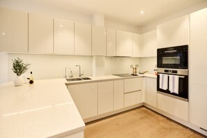 Enjoy cooking in this well-lit kitchen with sleek cabinetry and a stainless steel oven.