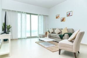 A modern living room with a sofa, a coffee table, and a TV stand.