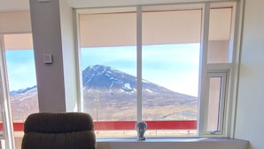 A room with a large window, a chair, and a wooden floor. - Hunavellir Guesthouse (Blönduós)