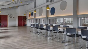 A spacious conference room with a long table and chairs, large windows, and a modern ceiling design. - Hunavellir Guesthouse (Blönduós)