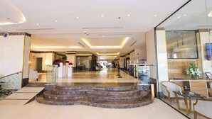 A hotel lobby with a marble staircase, a reception desk, and a glass wall. - diamond vision hotel (Jeddah)