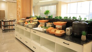 A buffet setup with various food items and a coffee machine. - diamond vision hotel (Jeddah)
