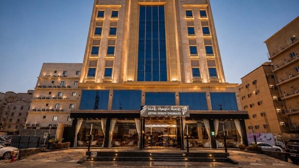 A multi-story hotel with a central entrance, a visible signboard, and a well-lit facade. - diamond vision hotel (Jeddah)