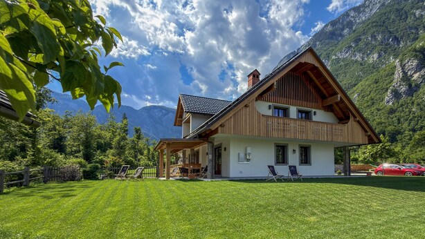 Een chalet met twee verdiepingen, een houten gevel, een balkon en een overdekt terras.