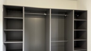 A walk-in closet with multiple shelves and hanging space, featuring a neutral color scheme and a modern design. - Comfortable gîte ideally located (Saint-Martin-d'Ardèche)