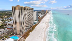 Un hotel di grandi dimensioni con numerosi balconi, una piscina e vista sulla spiaggia.
