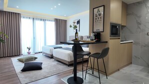 Une chambre d’hôtel moderne équipée d’un lit, d’une petite table à manger avec des chaises, d’une télévision et d’une machine à café.