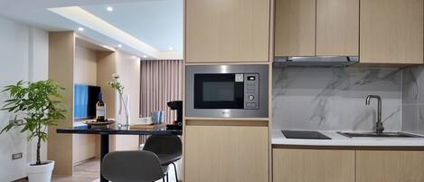 A modern kitchen with a built-in microwave, a stainless steel sink, and wooden cabinets.