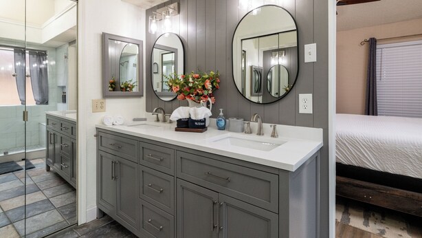 A modern bathroom with a double sink vanity, large mirrors, and a shower area. - 
Pool, Game Room + Office - Near the Frisco Star (Frisco)
