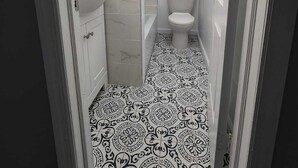 Un baño estrecho con inodoro, lavamanos y ducha.