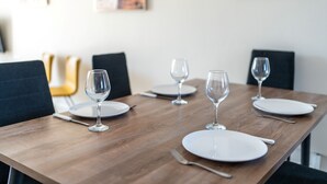 A dining table set with white plates, cutlery, and wine glasses. - Narcissos Nissi Beach Apartment D12 (Ayia Napa)