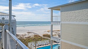 A beachfront property with a pool, beach view, and a covered patio area. - Festival Sale! Beachside Paradise~2/1~Heated Pool (Gulf Shores)