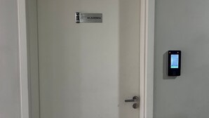 En dörr med en skylt där det står ”ACADEMIA” och ett digitalt lås på väggen.