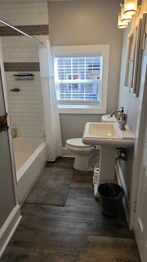 Un baño pequeño con ducha, inodoro y lavabo.