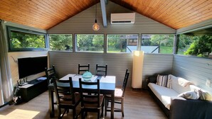Un patio coperto con tavolo e sedie, un divano e una TV.