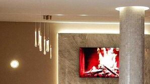A modern lounge area with a sofa, ottoman, and a round table. - Hotel Donia Sfax (Sfax Ouest)