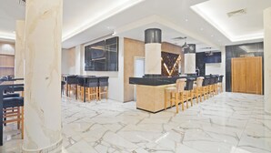 A spacious kitchen with a central island, marble flooring, and modern lighting fixtures. - Hotel Donia Sfax (Sfax Ouest)