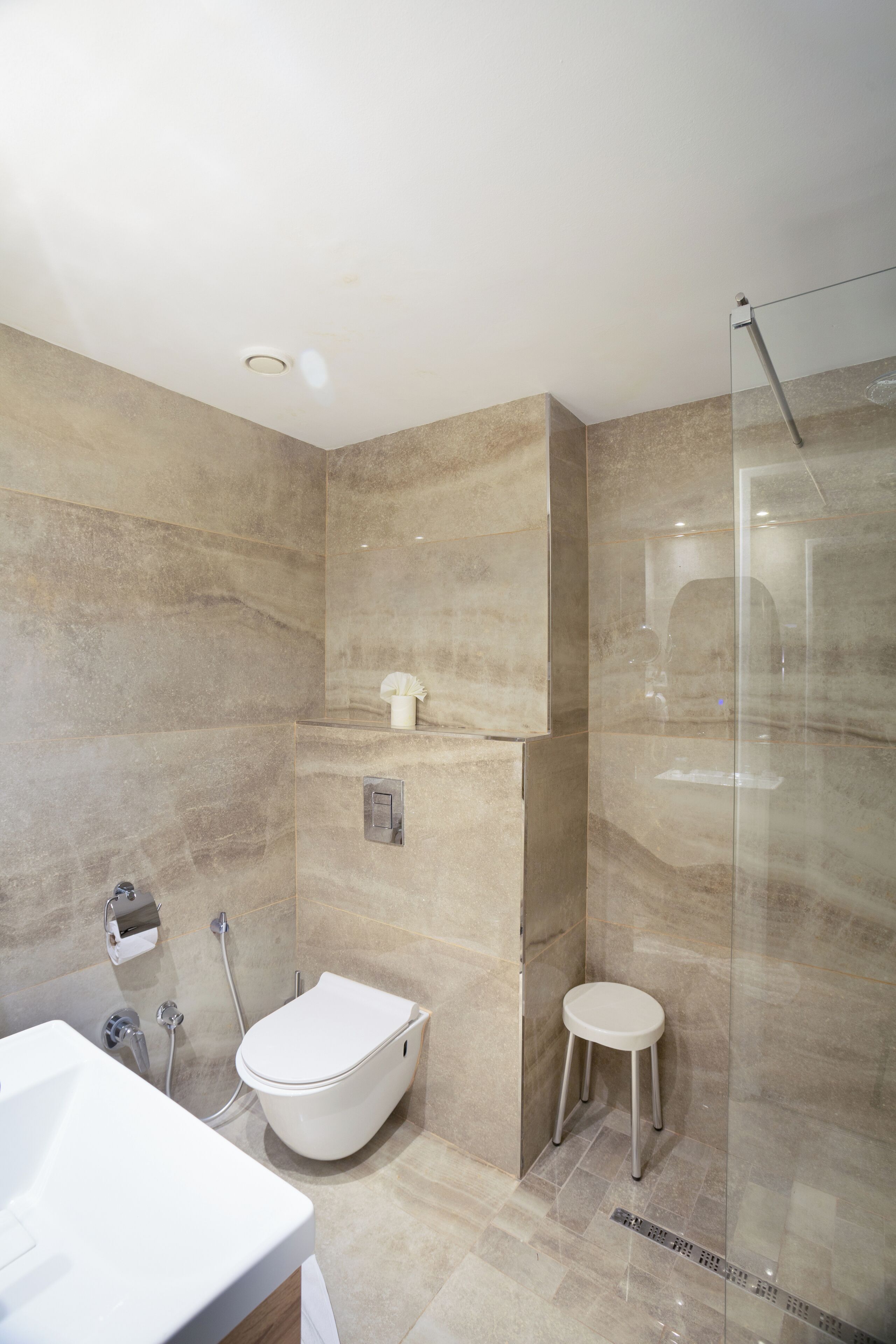 A modern bathroom with a freestanding bathtub, a toilet, and a glass-enclosed shower area.