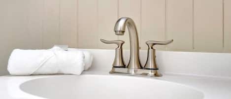 A bathroom with a white sink and a single faucet.