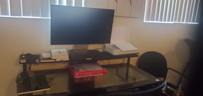 Una scrivania con un monitor, tastiera e mouse. C'è una scatola rossa sul piano.