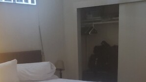 Une chambre à coucher avec un lit, une armoire et une fenêtre.