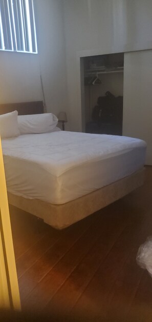 Una camera da letto con un letto, un armadio e una finestra.