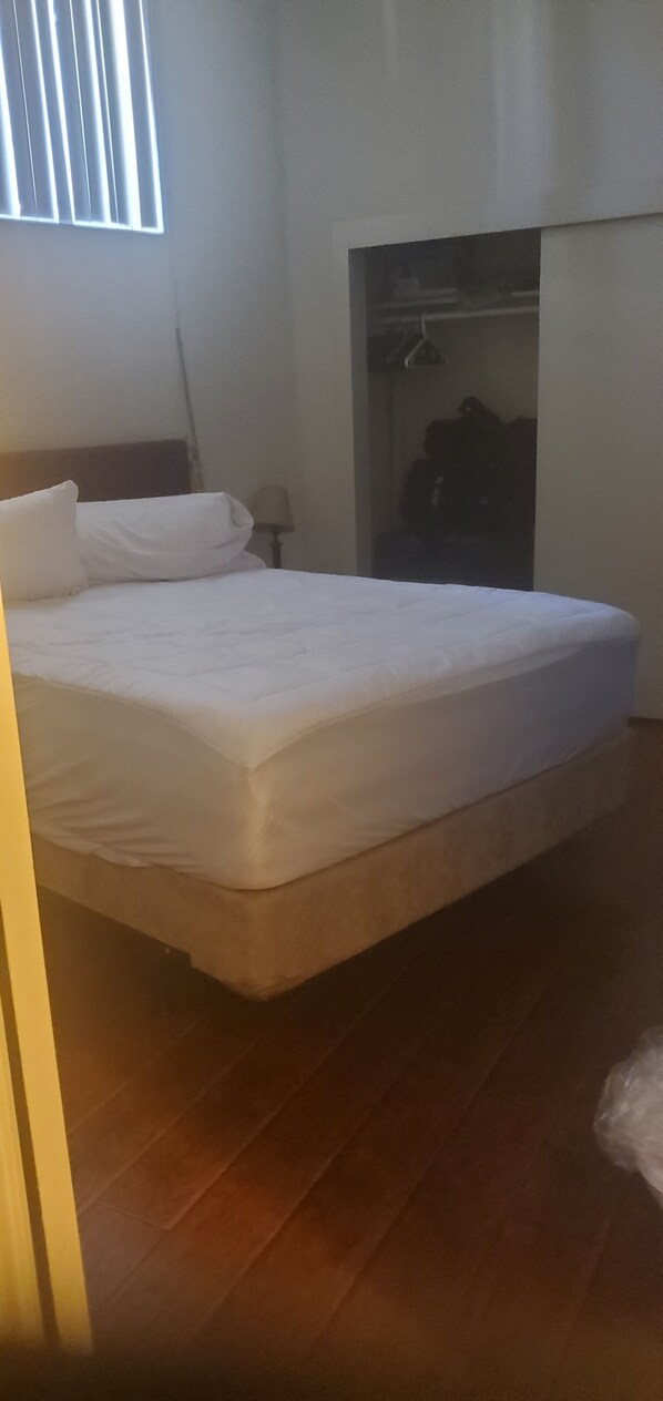 Une chambre à coucher avec un lit, une armoire et une fenêtre.