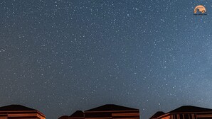 A starry night sky with several illuminated structures, possibly a resort or hotel, under a clear sky. - Wadi Rum Magic Nature Camp (Wadi Rum)