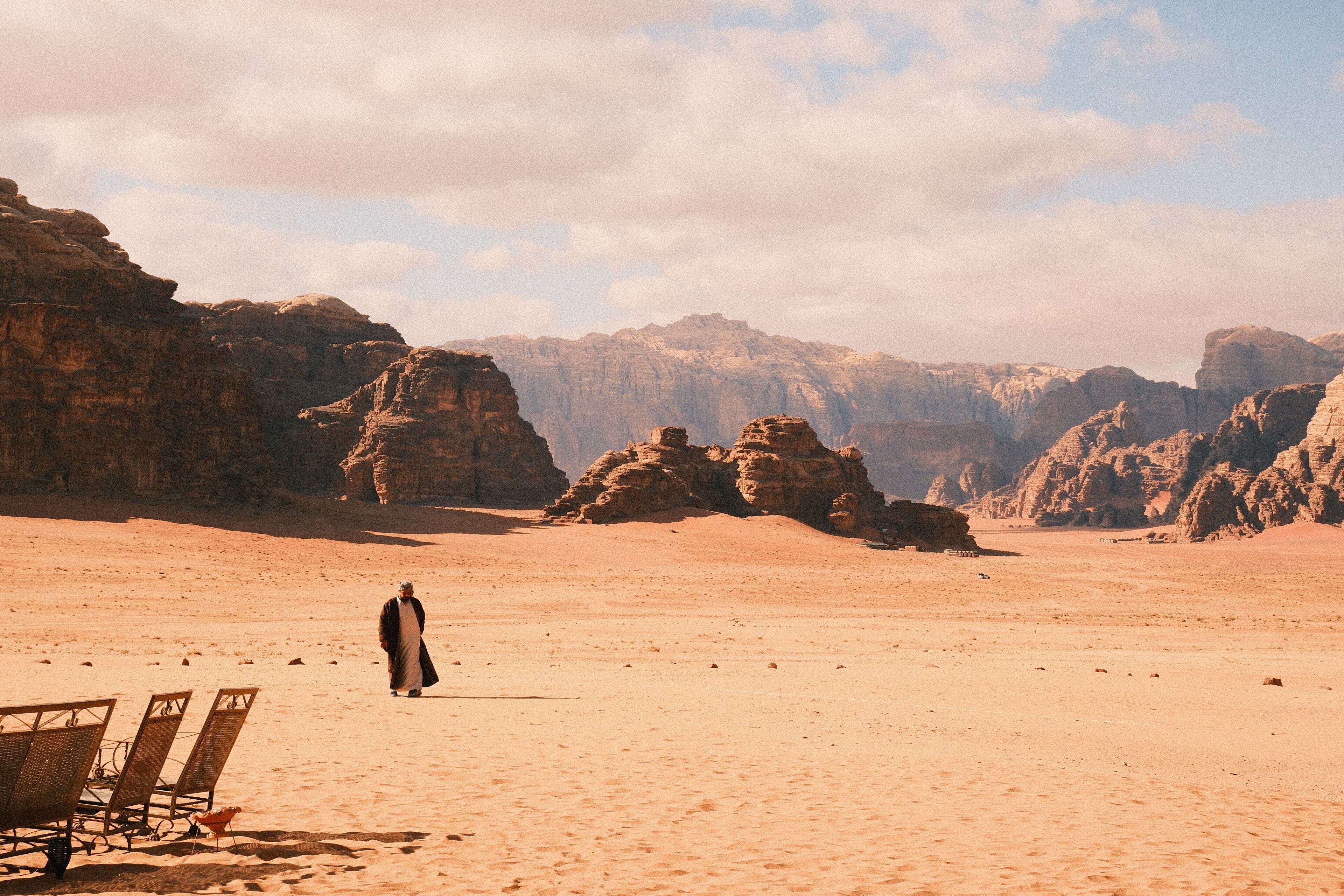 A desert landscape with rocky formations and a person standing in the distance.